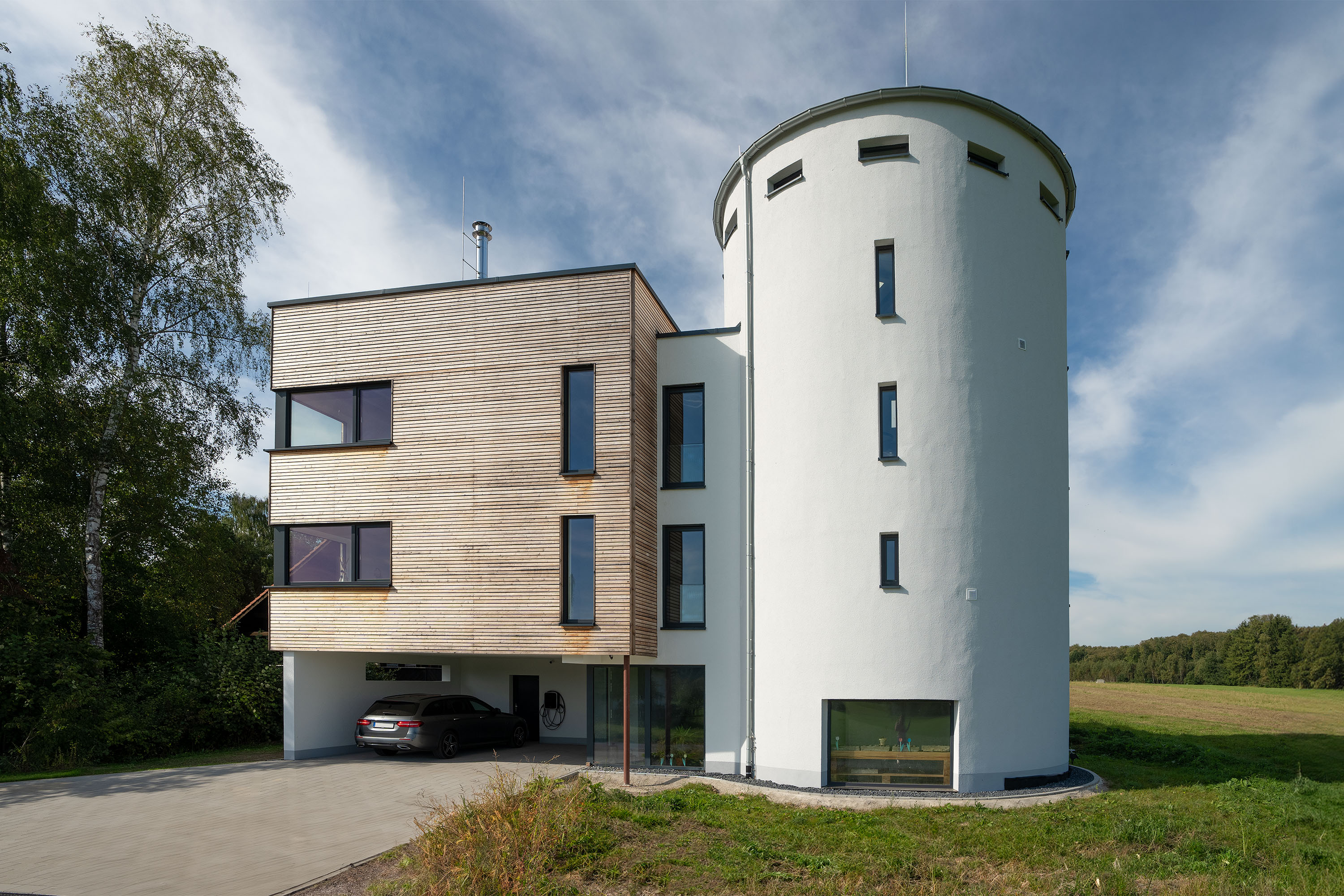 Anbau an Turmgebäude mit Holzfassade